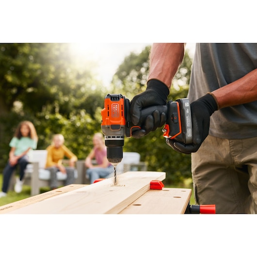A wooden plank being drilled into using the BLACK+DECKER® POWERCONNECT™ 18V Cordless Drill Driver.