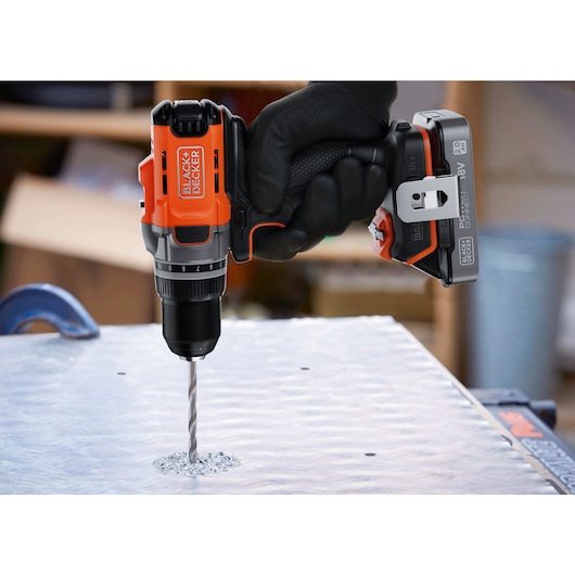 A metal sheet being drilled into using the BLACK+DECKER® POWERCONNECT™ 18V Cordless Drill Driver.
