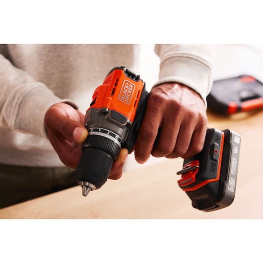 A man adjusts the clutch position of the BLACK+DECKER® POWERCONNECT™ 18V Cordless Drill Driver.