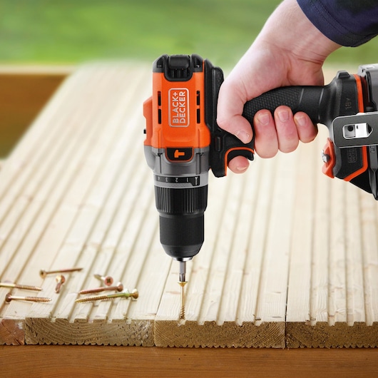 Wooden decking being drilled into using the BLACK+DECKER® POWERCONNECT™ 18V Cordless Hammer Drill.