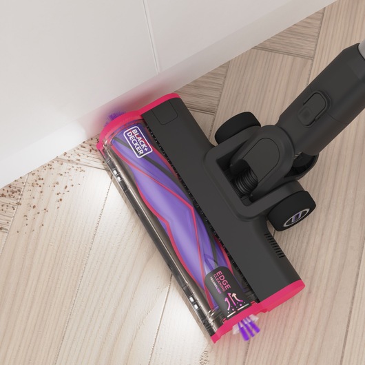Overhead view of the edge-to-edge cleaning capturing debris alongside a skirting board - BLACK+DECKER SUMMITSERIES select cordless stick vacuum.