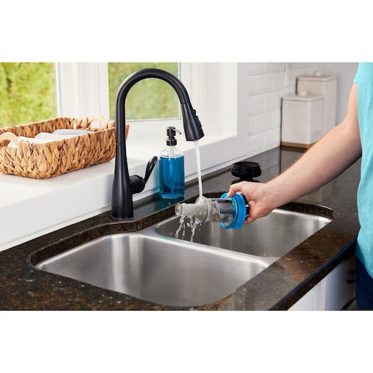 Man cleaning the cyclones of the POWERSERIES Extreme MAX cordless stick vac under water in a sink