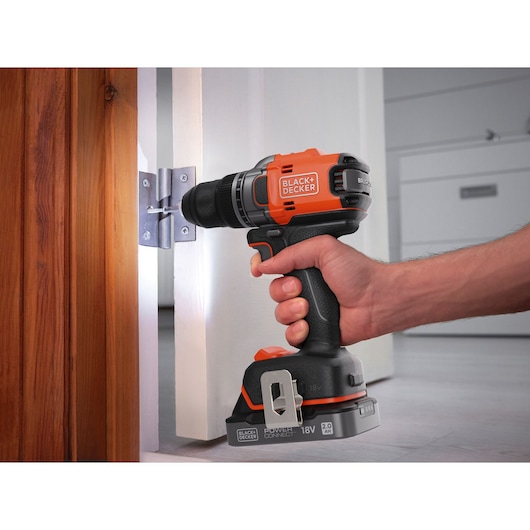A door hinge being secured with a screw using the BLACK+DECKER® 18V POWERCONNECT™ Brushless Drill Driver.