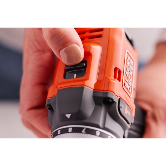 Close-up photo of hand adjusting BLACK+DECKER BLD683D1 orange and black cordless drill switch.