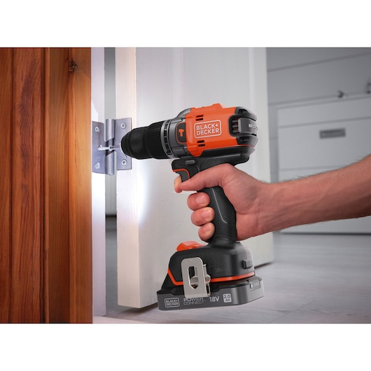 A door hinge being secured with a screw using the BLACK+DECKER® 18V POWERCONNECT™ Brushless Hammer Drill.