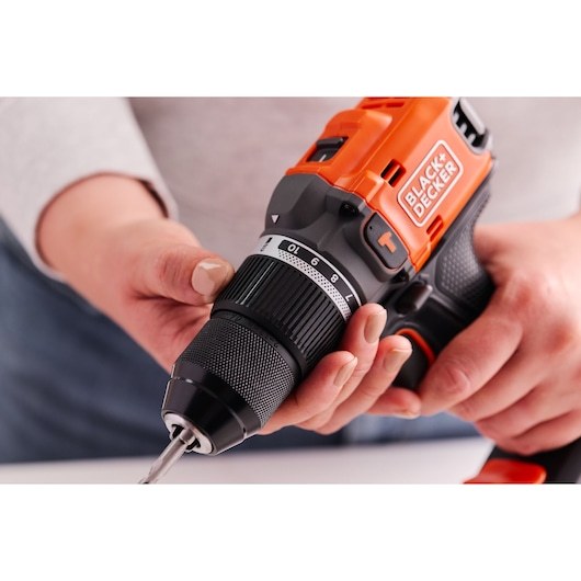 A hand adjusts the clutch position of the BLACK+DECKER® 18V POWERCONNECT™ Brushless Hammer Drill to drill mode.