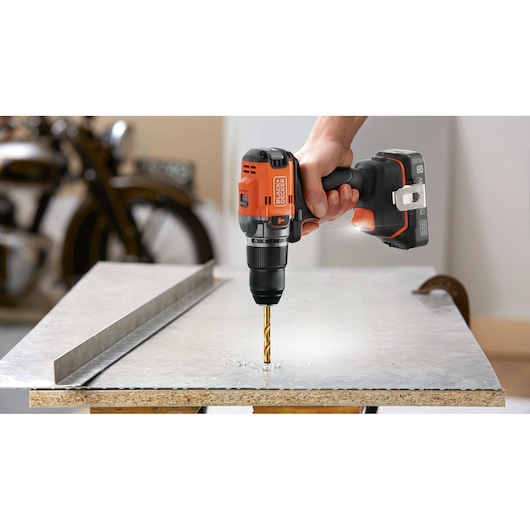 A metal sheet being drilled into using the BLACK+DECKER® 18V POWERCONNECT™ Brushless Hammer Drill.