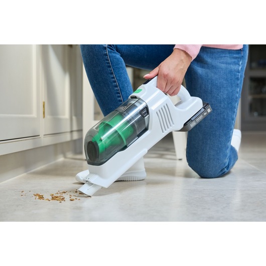 Cereal on a tile floor being vacuumed with the handheld mode BLACK+DECKER® 18V reviva™ POWERCONNECT™ Stick Vacuum.