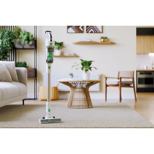 The BLACK+DECKER® reviva™ 18V POWERCONNECT™ Cordless Stick Vacuum self-standing in a living room.