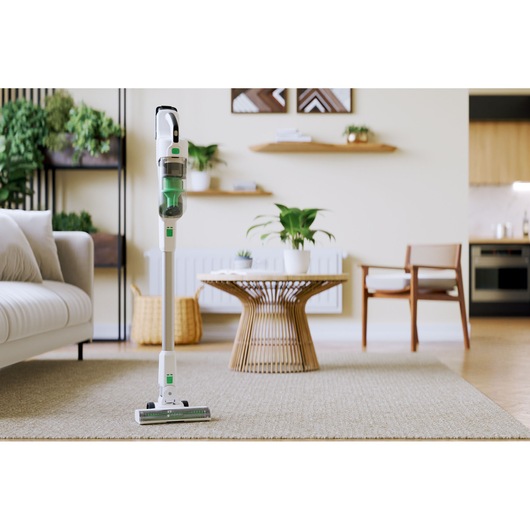 BLACKDECKER REVSV18D1 cordless stick vacuum cleaner standing on a beige carpet in a modern living room.
